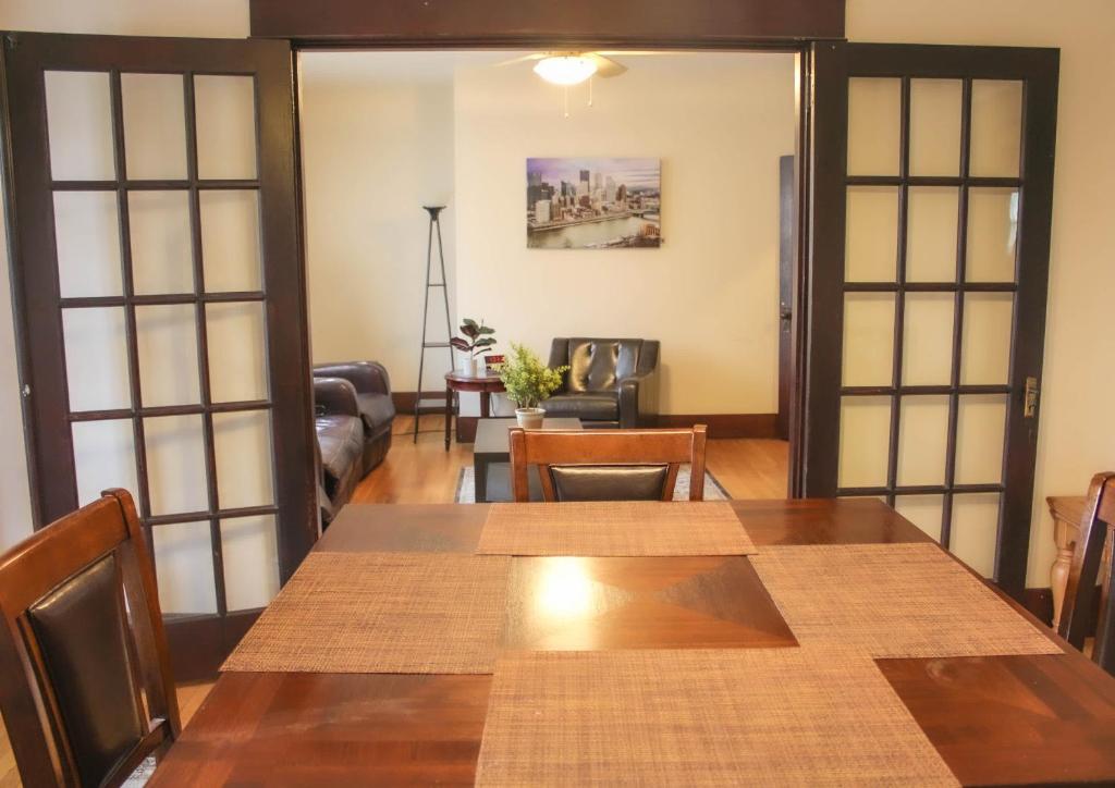 a dining room with a table and a living room at Comfy and Spacious 3 BR - Easy City Access in Pittsburgh