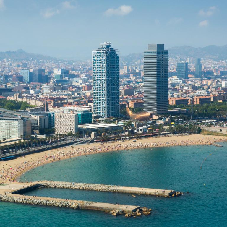 a beach with a group of people in the water at TOC Hotel Las Ramblas in Barcelona