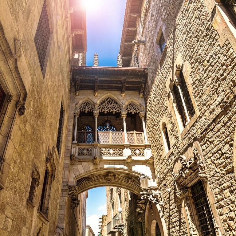 an old building with an arch and a balcony at TOC Hotel Las Ramblas in Barcelona