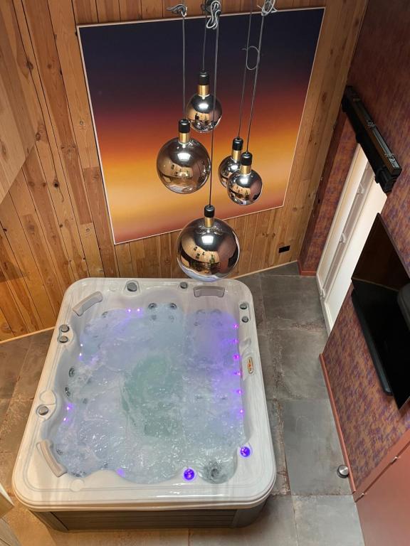 uma banheira de hidromassagem num quarto com luzes em Blackroom em Theux