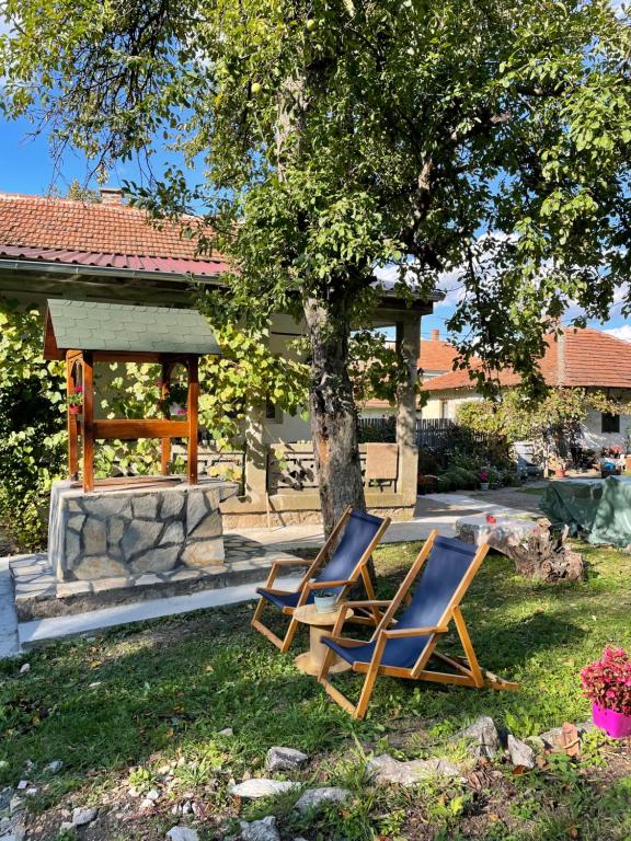 two lounge chairs in a yard with a gazebo at Idila pod Rtnjem - Najam cele vikendice sa bazenom in Ilino