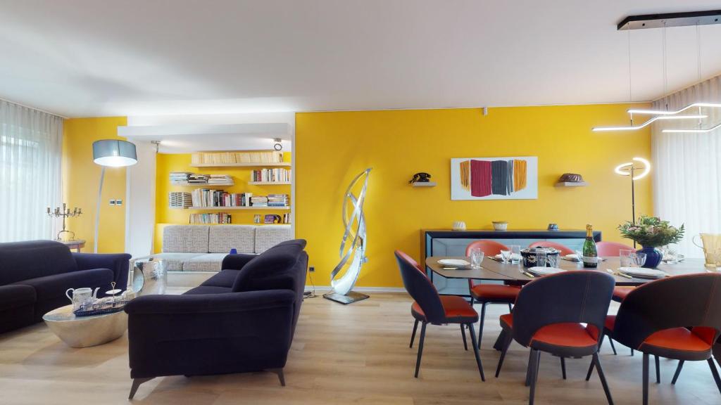 - un salon avec des murs jaunes, une table et des chaises dans l'établissement Maison Mandarine Colmar 5 bedrooms 180m2, à Colmar