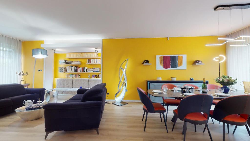 a living room with yellow walls and a table and chairs at Maison Mandarine Colmar 5 bedrooms 180m2 in Colmar