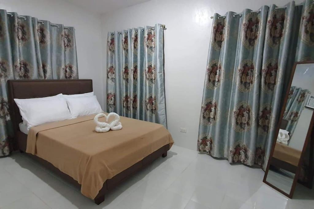 a bedroom with a bed with two towels on it at TymCast's Place - 2 Story house in Kabankalan