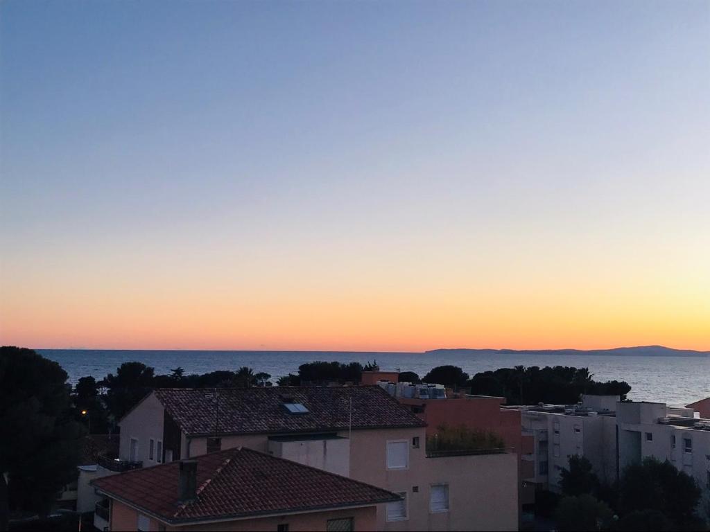 a view of a city at sunset at Appartement Saint-Raphaël in Saint-Raphaël