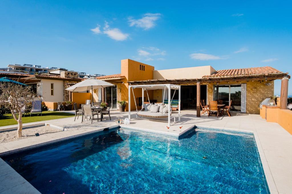 a swimming pool in front of a house at Ocean view, pool & gated community in Cabo San Lucas