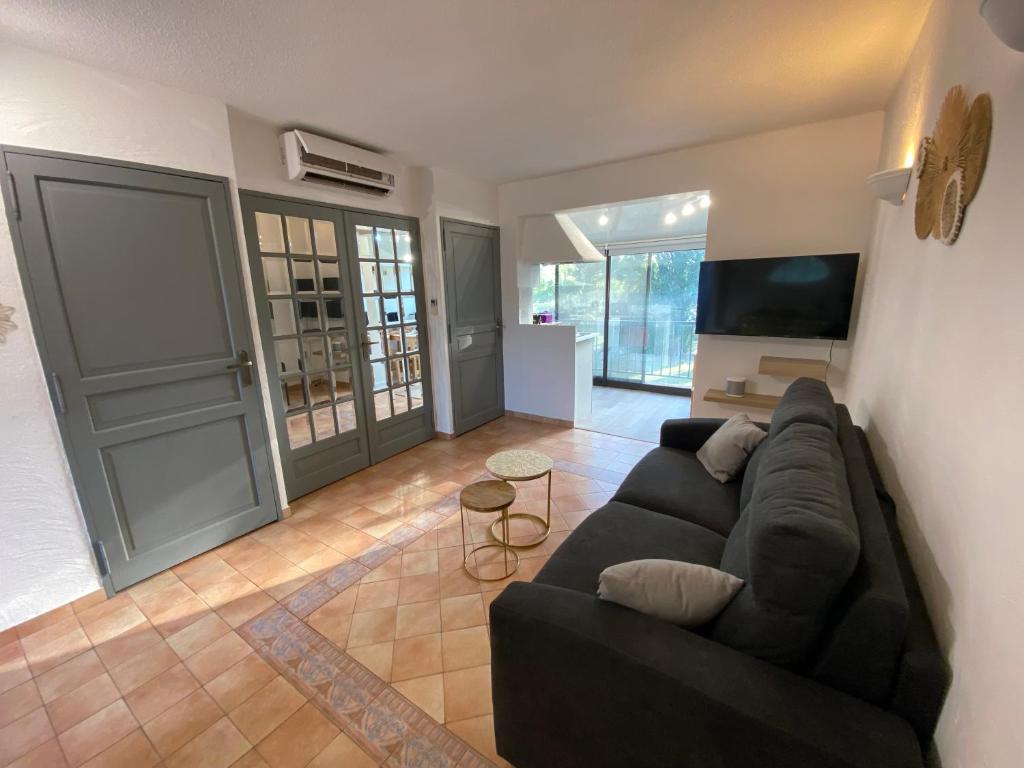 un salon avec un canapé et une télévision à écran plat dans l'établissement Joli appartement cosy, à Arles