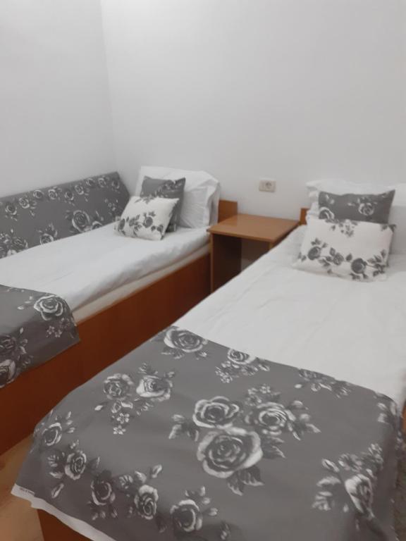 two beds with black and white blankets and pillows at Pensiunea Casa Brancusi in Peştişani