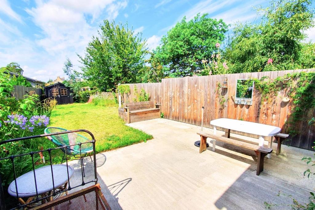 d'un jardin avec un banc et une clôture en bois. dans l'établissement Nice nest with garden in the city center, à La Gouesnière