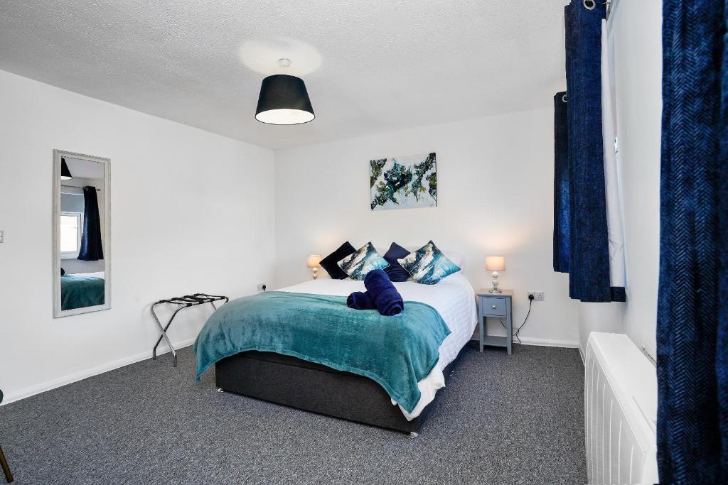 a bedroom with a bed with a blue blanket at Springland Close in Ipswich