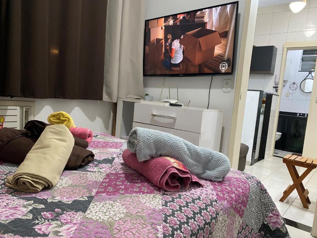 1 dormitorio con 1 cama y TV en la pared en Santana Temporada - Nossa Senhora de Copacabana Apartments, en Río de Janeiro