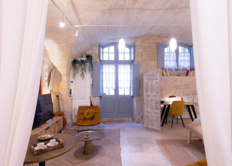 ein Wohnzimmer mit einer großen Tür und einem Tisch in der Unterkunft La DAME de FLAUX in Uzès