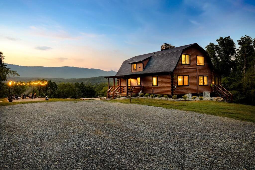 a large wooden house on a gravel road at Riverside Rose Cabin: Luxe*LogCabin*MtnView*Sleeps12*Secluded*Shenandoah in Rileyville