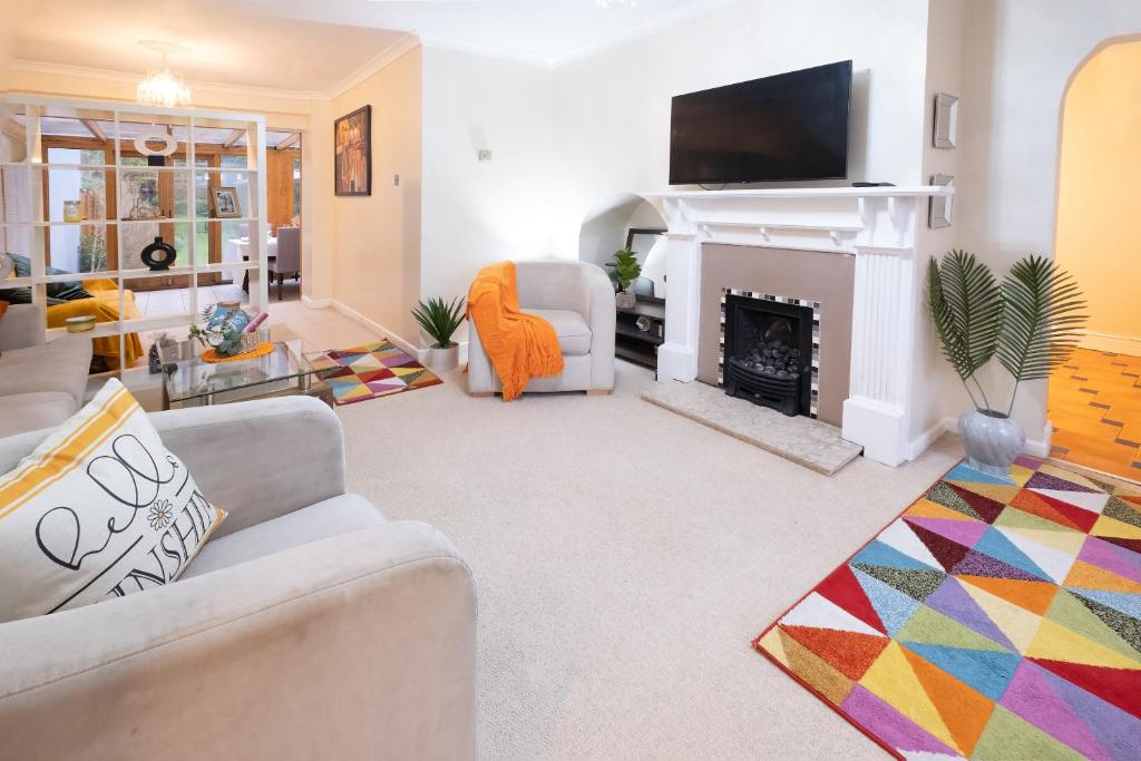 a living room with a fireplace and a tv at Charming family house in High Wycombe in Buckinghamshire