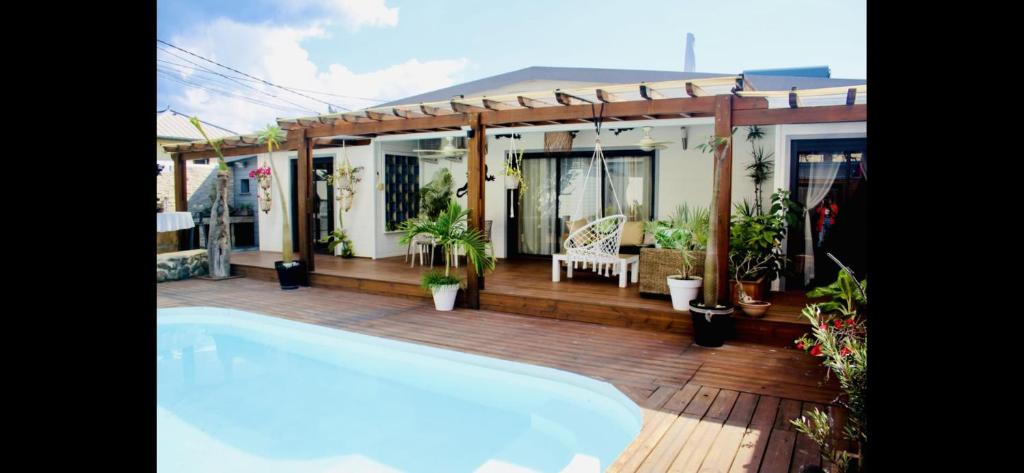 a swimming pool on a deck next to a house at Villa with pool close to the sea in Saint-Gilles les Bains