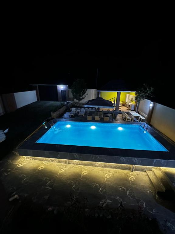 een groot zwembad met verlichting bij Xanagah Villa in İsmayıllı