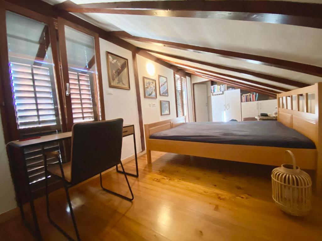 1 dormitorio con 1 cama y 1 silla en Romantic maisonette, en Piran