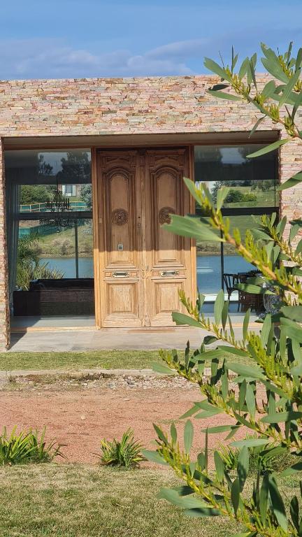 un edificio con una puerta de madera en un patio en Ventarrón Pueblomio Manantiales, en Manantiales