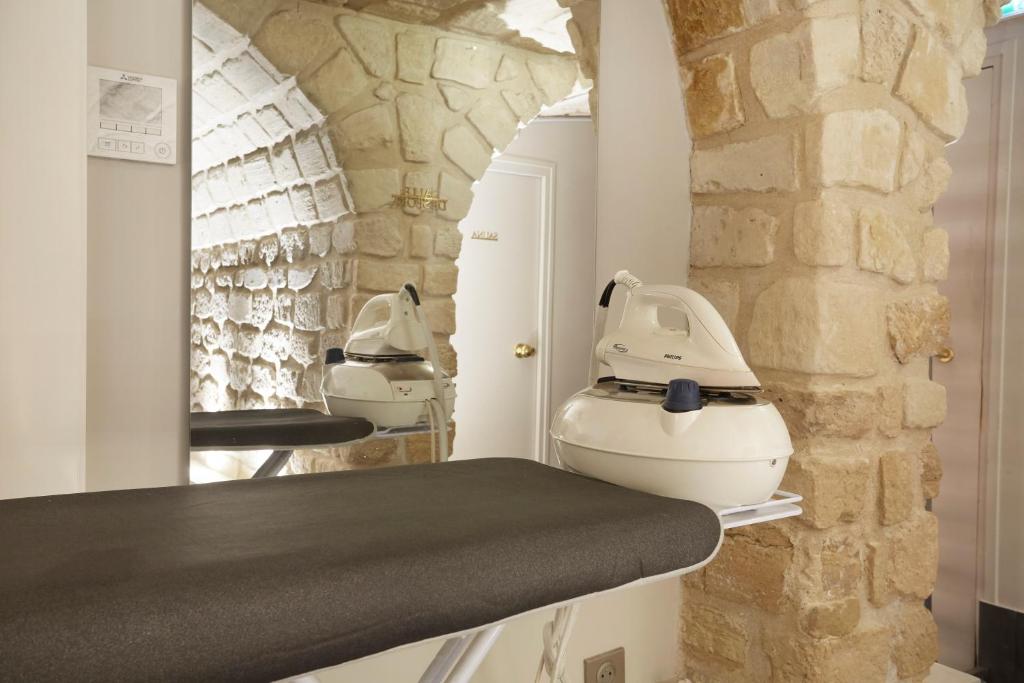 a barber shop with two sinks and a stone wall at Jardin de Villiers in Paris