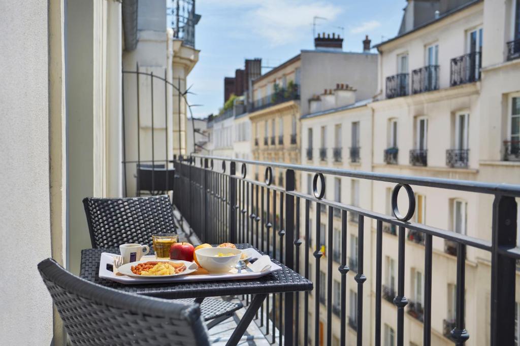 a tray of food on a table on a balcony at Jardin de Villiers in Paris