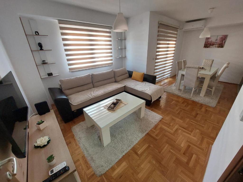 ein Wohnzimmer mit einem Sofa und einem Tisch in der Unterkunft Apartment Gelić Family in Kumanovo