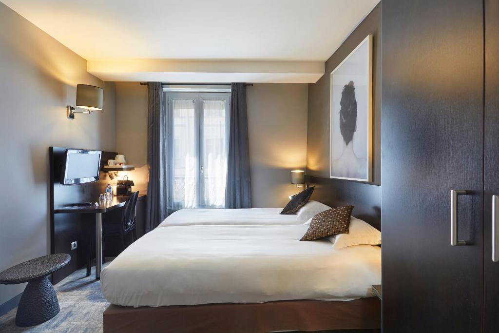 a hotel room with a large bed and a window at Jardin de Villiers in Paris