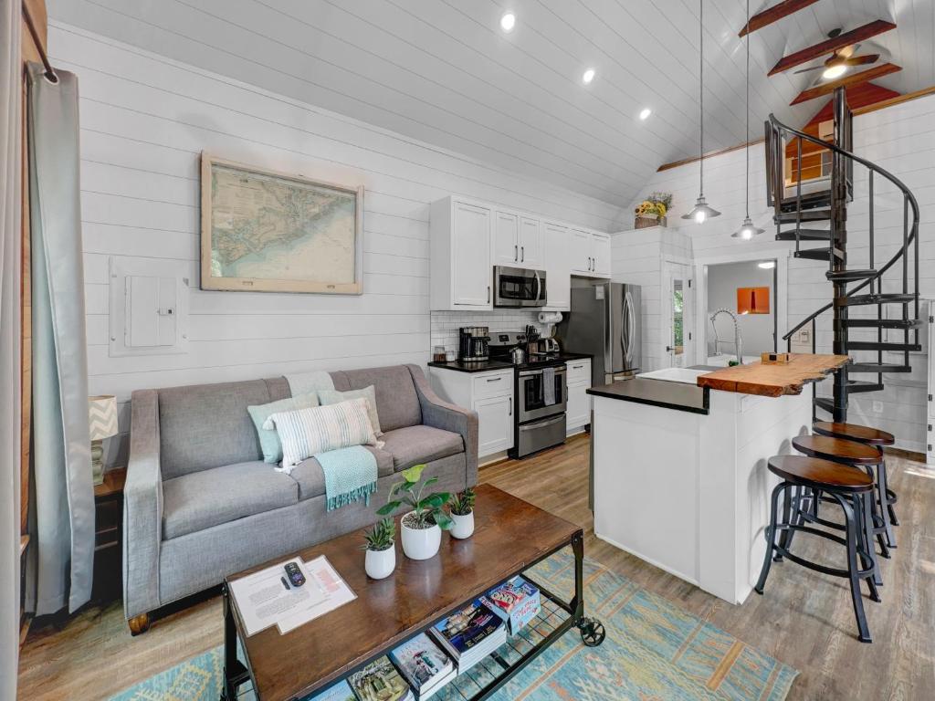 a living room with a couch and a kitchen at Cozy Island Cottage in Charleston