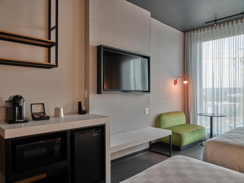 a hotel room with a bed and a television at Alt Hotel Calgary University District in Calgary