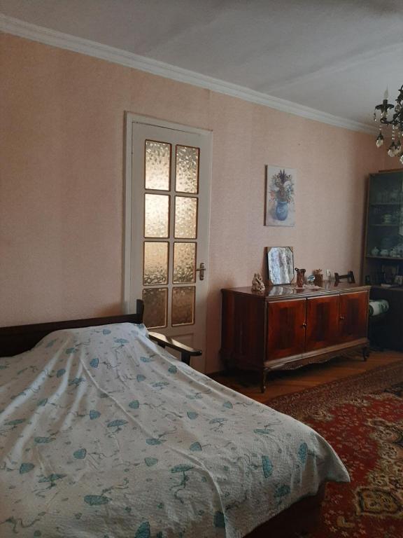a bedroom with a bed and a dresser and a window at hotel in chiatura in Chiatʼura