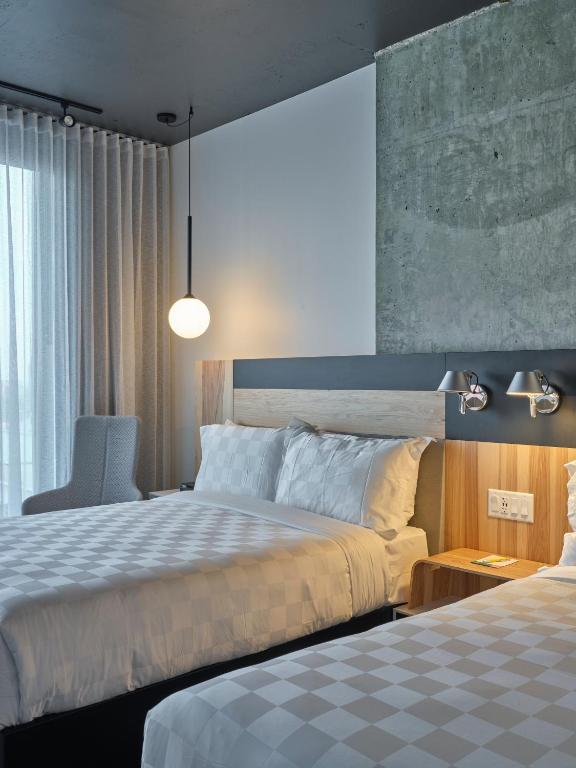 a hotel room with two beds and a chair at Alt Hotel Calgary University District in Calgary