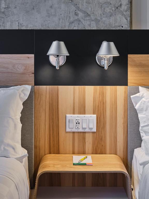 a room with two beds and a table with a light at Alt Hotel Calgary University District in Calgary
