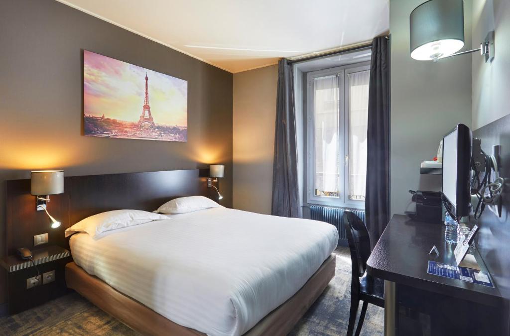 a hotel room with a bed and a desk and a window at Jardin de Villiers in Paris