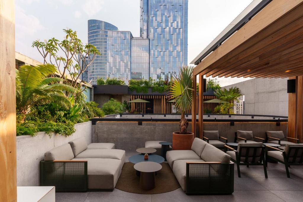 a rooftop patio with furniture and tables and a city at Volga in Mexico City