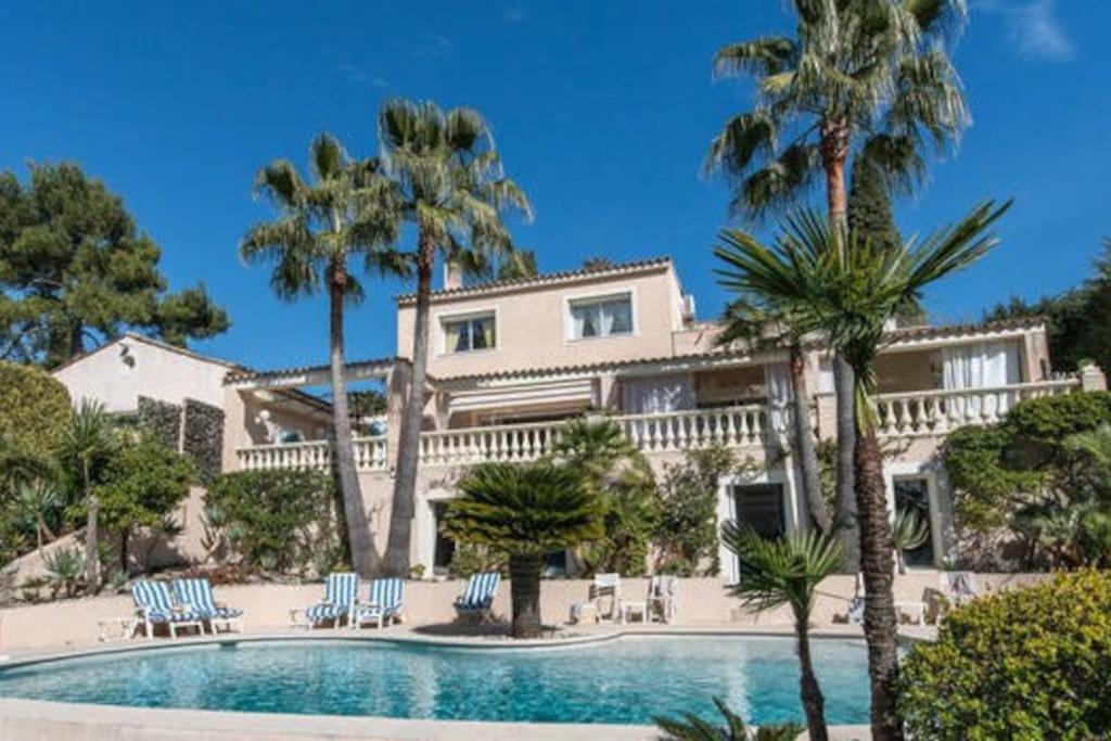 a large house with palm trees and a swimming pool at Villa spa hamman sauna in Juan-les-Pins