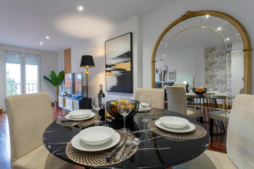 a dining room with a table and a mirror at Cinco Sentidos by Unique Rooms in Burgos