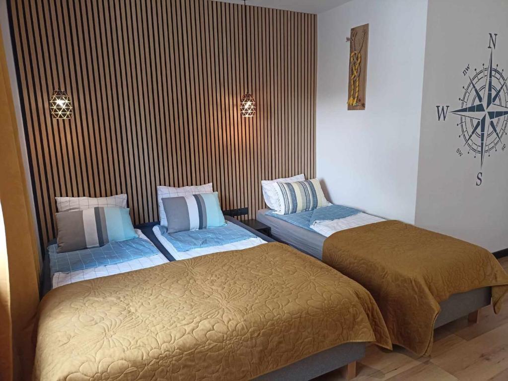 twee bedden naast elkaar in een kamer bij Big Blue Apartments nr 6 - 3 osobowy in Władysławowo