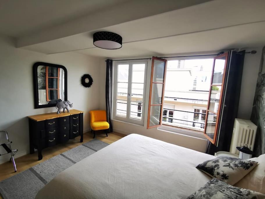 1 dormitorio con 1 cama, 1 silla y ventanas en Mademoiselle de Champmeslé, en Rouen