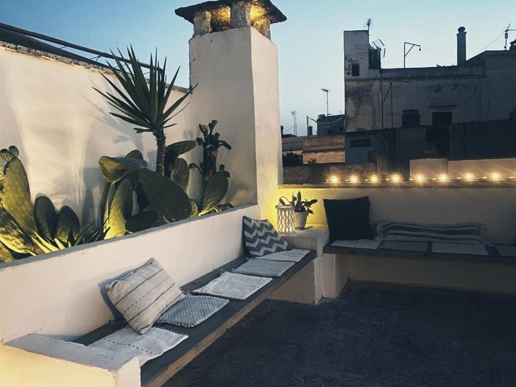 a balcony with pillows and plants on a building at Casa Annina in Gallipoli