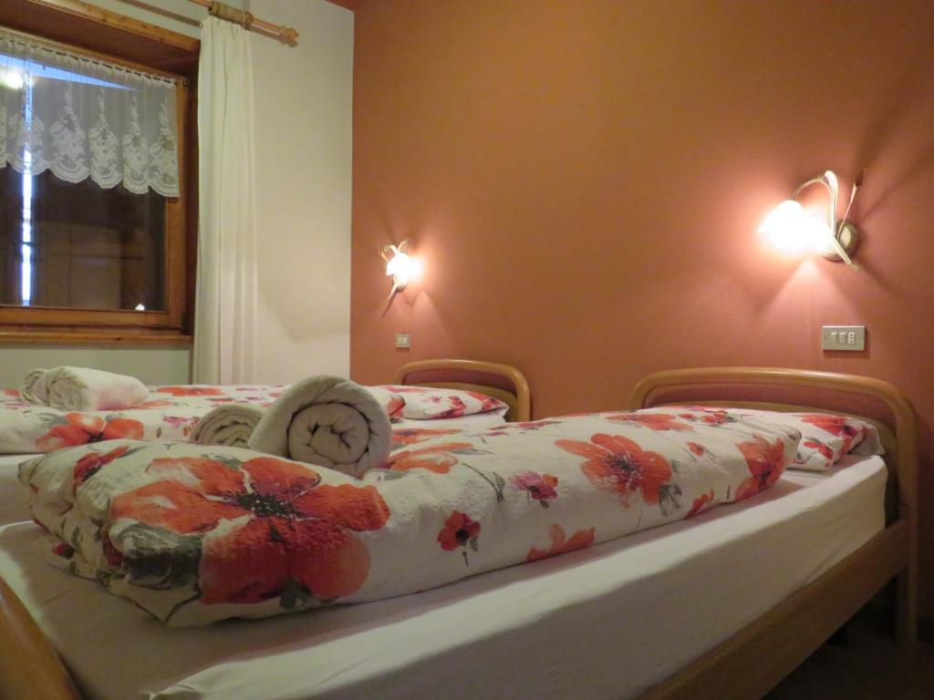 a bedroom with two beds with a clock on them at Giglio Della Montagna in Livigno