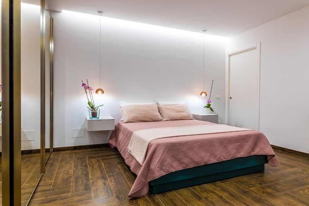 1 dormitorio con cama y pared blanca en Rosina Apartment surfing bed&vacation, en Terrasini