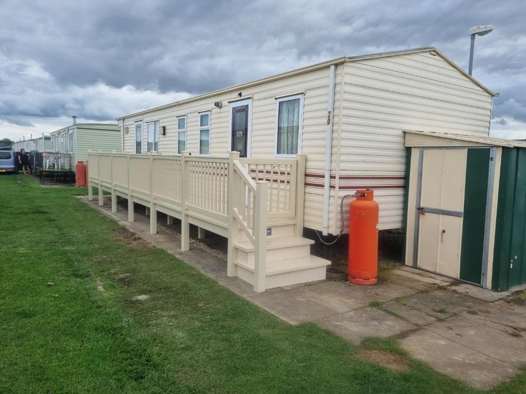 a mobile home with a fire hydrant in front of it at S407 8 BERTH 3 BED CARAVAN GOLDEN PALM in Chapel Saint Leonards