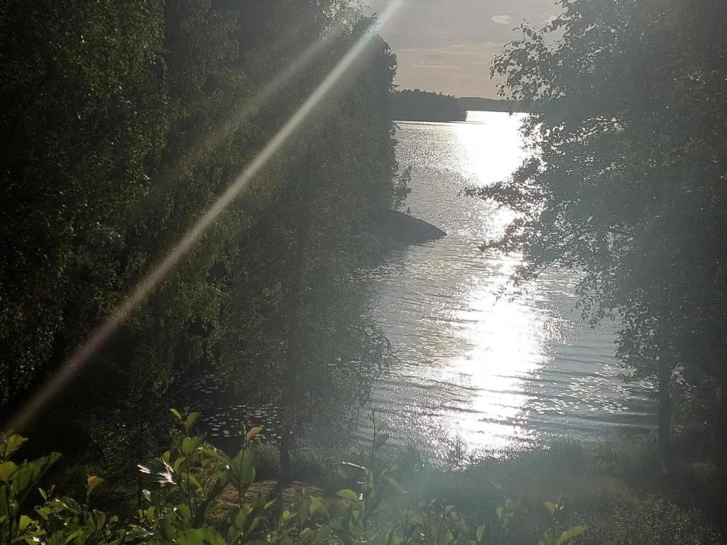 a river with the sun shining on the water at Lakeside Villa Lehtiniemi in Pirkkala