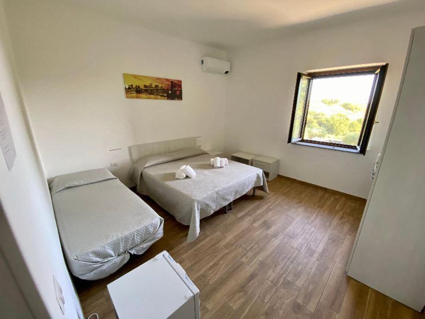 a small room with two beds and a window at La Conchiglia in San Nicola Arcella