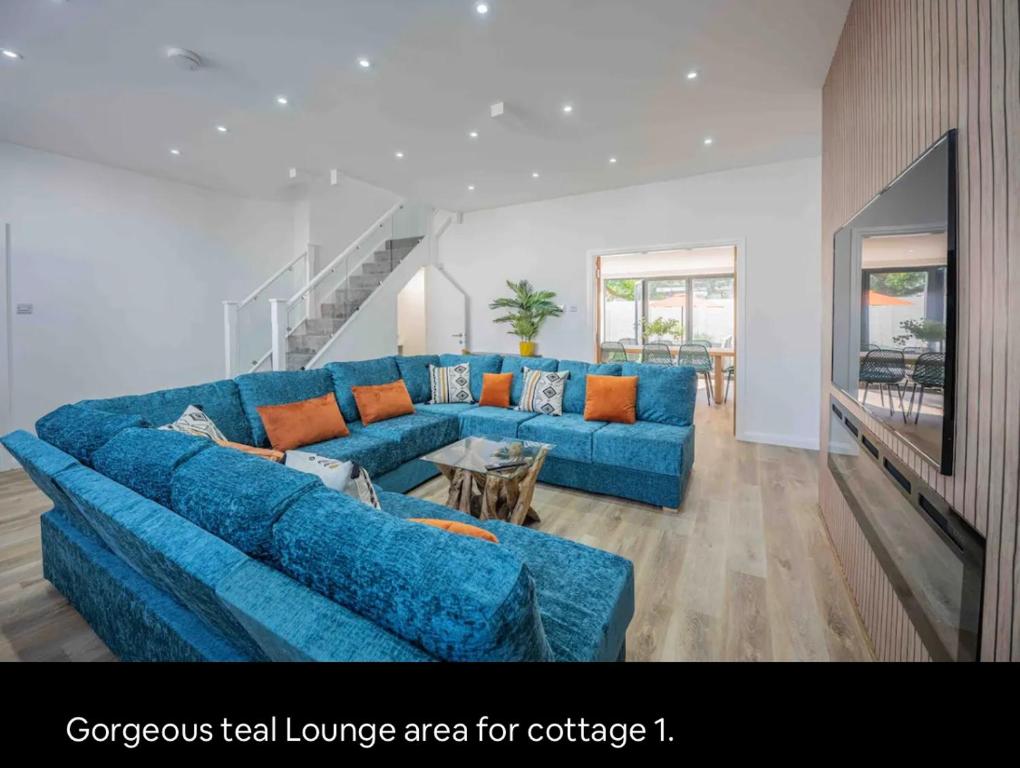 a living room with a blue couch and a table at The Old School Sleeps 14 in Lymington