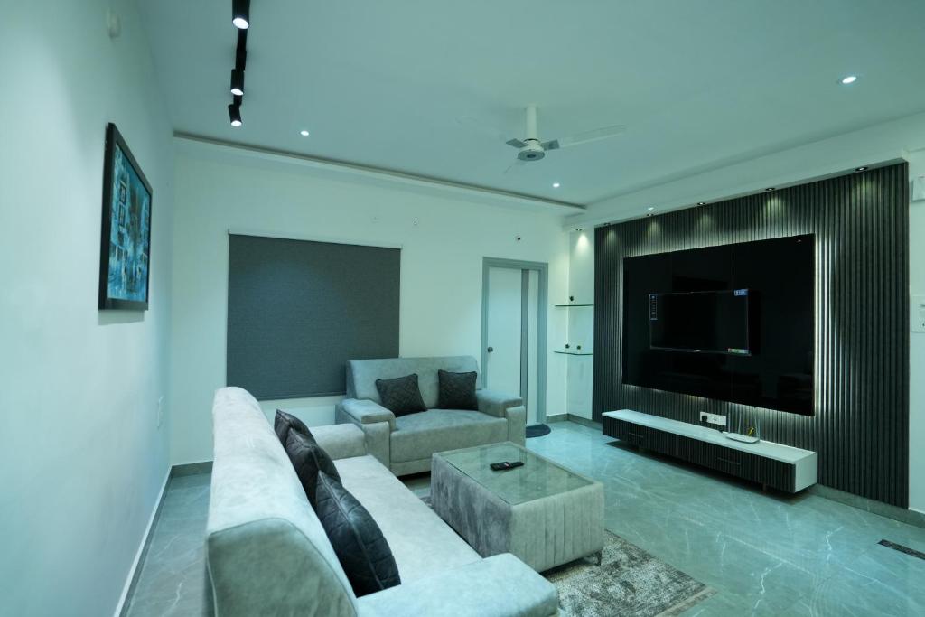 un soggiorno con divano e TV a schermo piatto di BIGSON SERVICE APARTMENTS MADHAPUR a Hyderabad