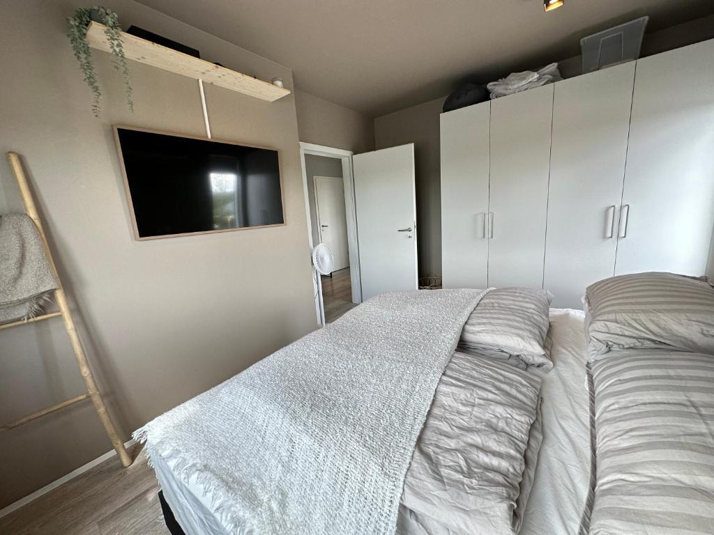 a bedroom with a bed and a flat screen tv at Apartment Lyngas - Birta Rentals in Garðabær