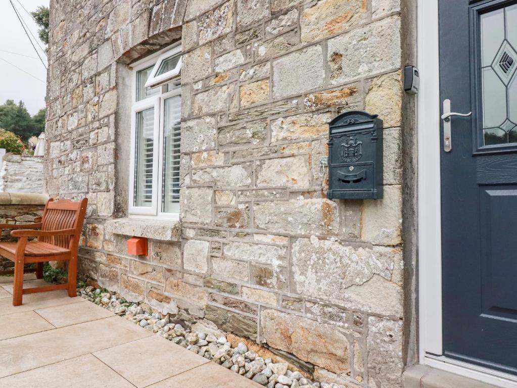 a stone house with a mailbox on the side of it at Still Waters in St Austell