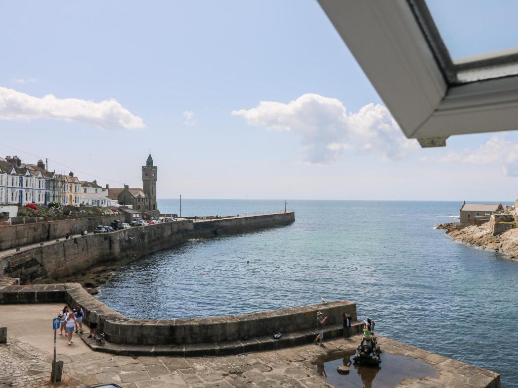 a view of a body of water with people walking on a pier at Sea Star in Porthleven