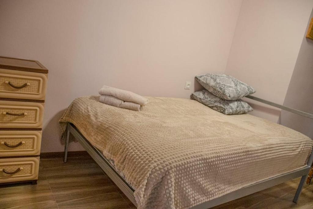 a bedroom with a bed with two pillows and a dresser at Lucy B&B in Garni