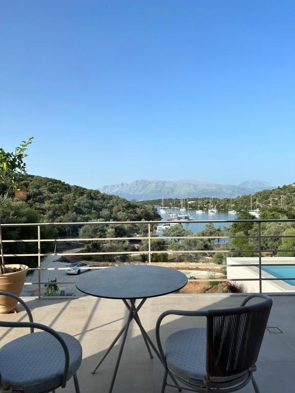 una mesa y sillas en un patio con vistas en Amphitheatro Boutique Hotel en Meganisi